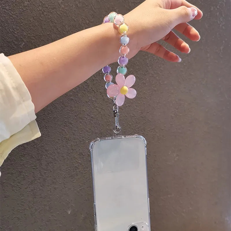 A hand is holding a phone anti-loss lanyard with a string of colorful round beads and a pink flower pendant.