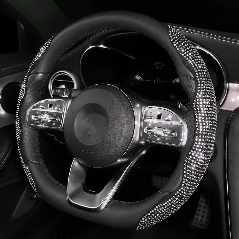 Gros plan d'un volant noir avec des coutures incrustées de diamants et des commandes.