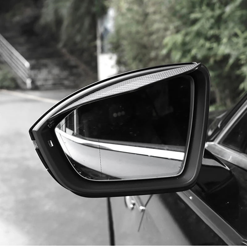 Close-up view of a black universal car rearview mirror with a textured visor.