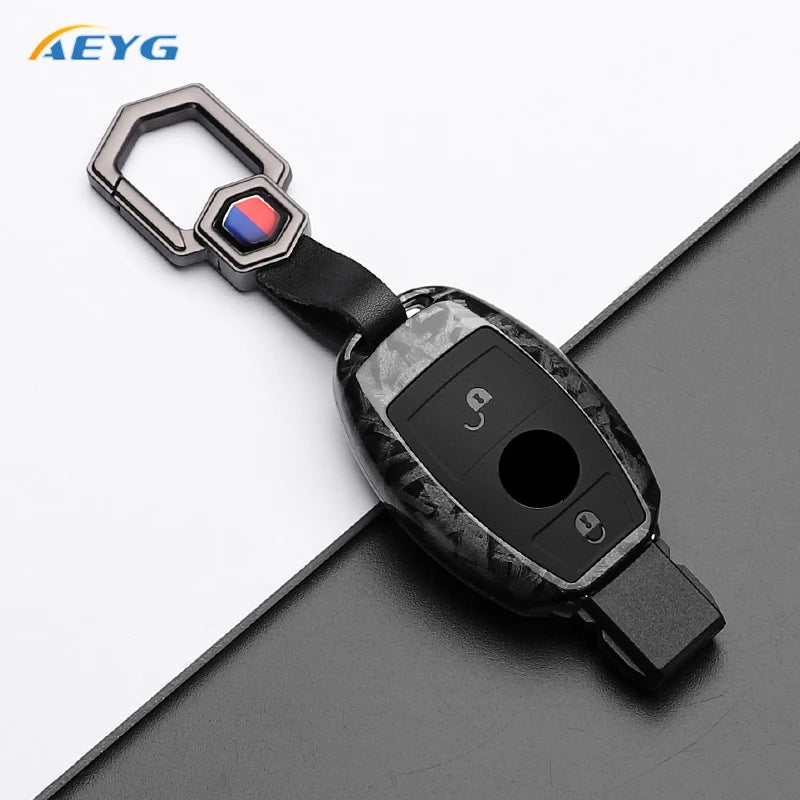 A black carbon fiber car key cover with a silver clasp and electronic components.
