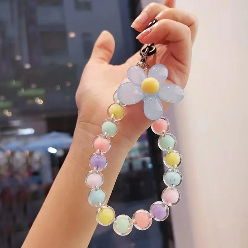 A hand holds a phone anti-loss lanyard featuring a round bead pendant with pastel colors like pink, yellow, and blue.