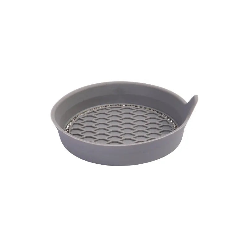Un juego de posavasos de cristal con pedrería para vasos de coche en un plato gris.