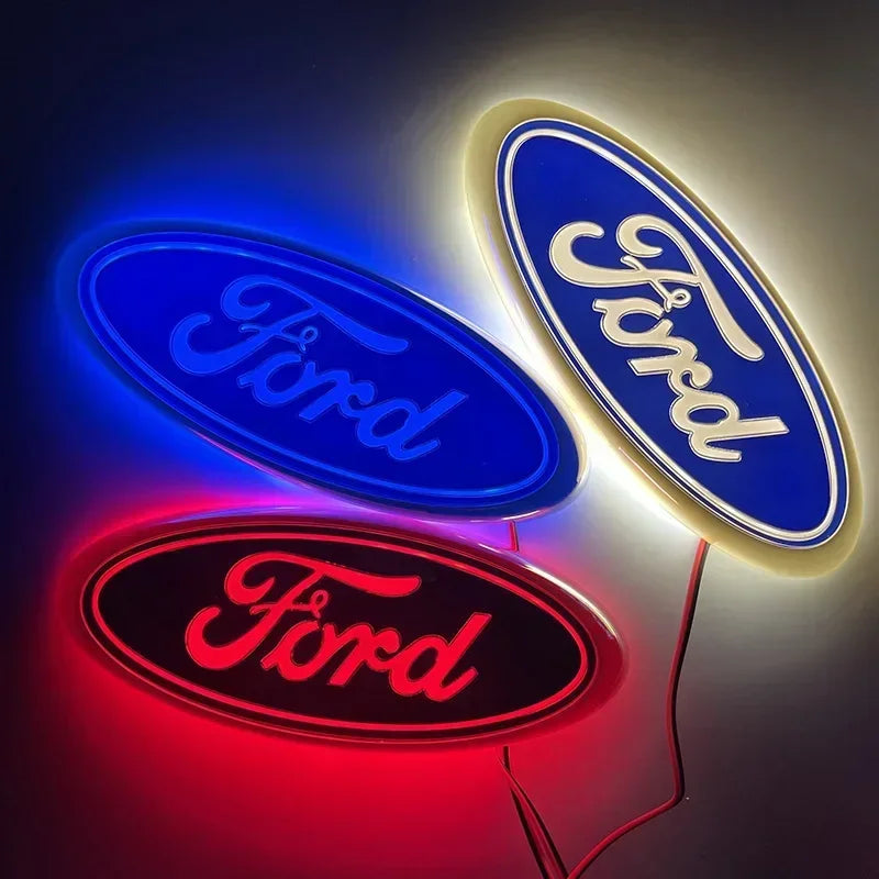 Three illuminated oval logos featuring the Ford name in blue, white, and red light.