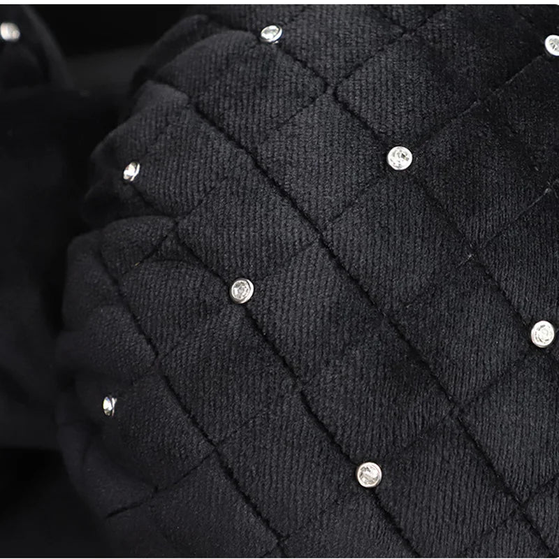Close-up of a black quilted car neck pillow featuring small clear diamond rhinestones.
