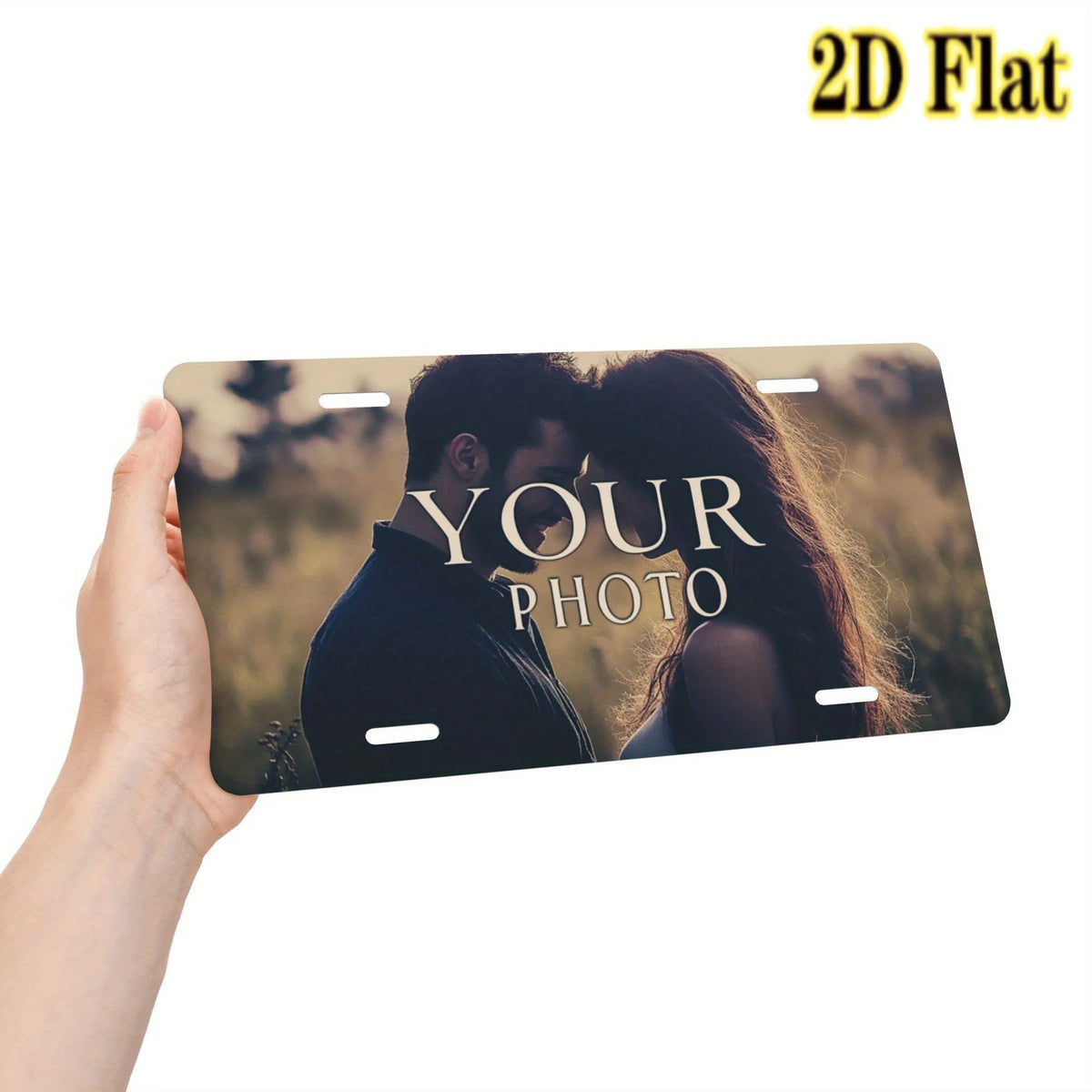 Una mano sostiene un letrero de matrícula metálico plano y personalizable 2D con la foto de una pareja.