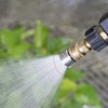Close-up of a high-pressure stainless steel shower head nozzle emitting a focused stream of water.