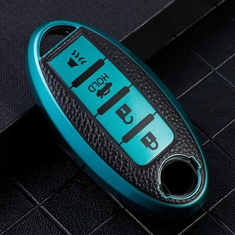 A teal car key fob cover with black markings for hold and unlock functions resting on a dark surface.