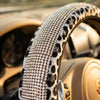 Close-up of a leopard print steering wheel cover with sparkling rhinestone accents.