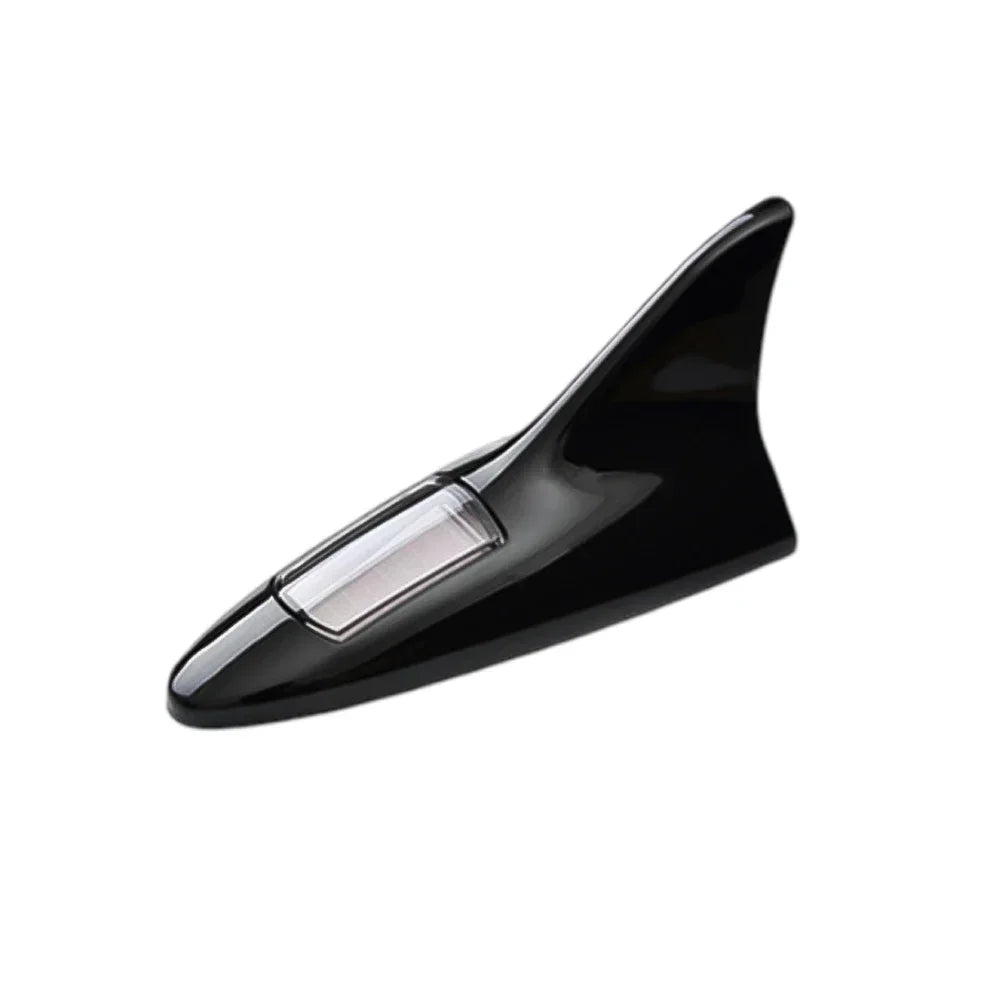 Black solar car antenna with a shark fin design mounted on a roof