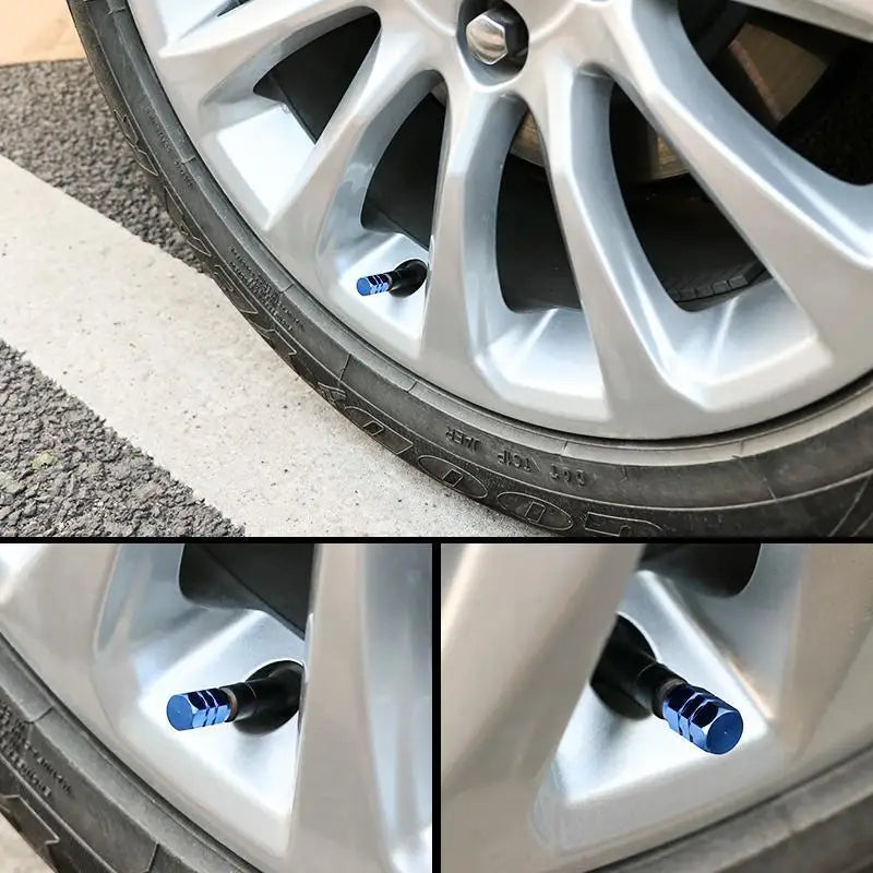 Close-up view of a silver alloy tire rim with four blue and black valve caps installed.