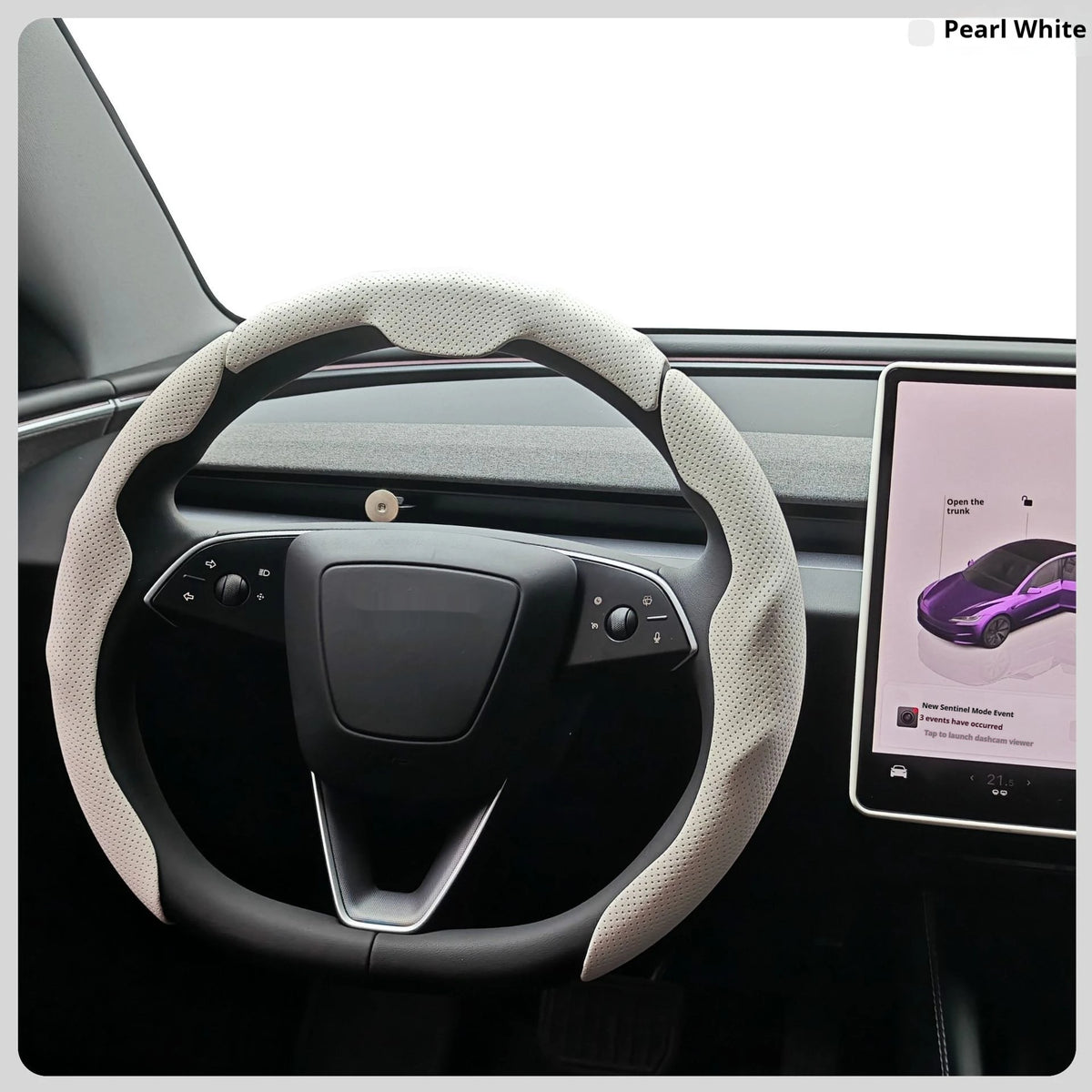 A close-up view of a steering wheel with a light beige leather cover, featuring controls and a modern interior.