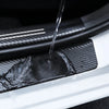 Close-up of a carbon fiber door sill protector being rinsed with water.