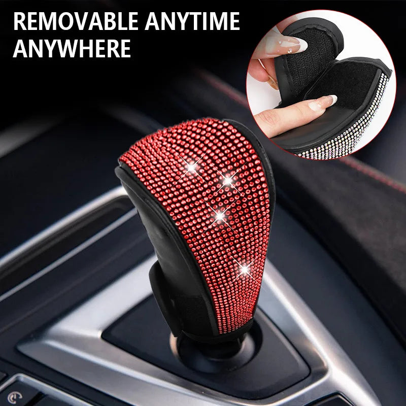 A close-up of a red rhinestone gear shift knob cover with a black PU leather protector shown in a car interior context.