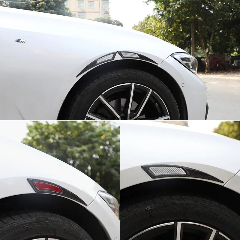 Close-up of a white car wheel with black carbon fiber eyebrow protector trim and tire.