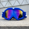 A pair of bright blue windproof sports goggles with mirrored lenses resting on a gray stone surface.