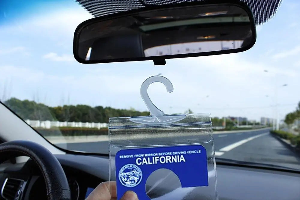 A transparent license plate holder with a hanging strap displaying the word California.