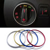 Set von vier bfarbigen Metallringen (silber, gold, blau, rot) als Zierleiste für Auto-Scheinwerfer-Schalter.