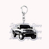 Silver acrylic keychain featuring a black off-road truck model.