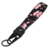 Black fabric wrist strap lanyard with pink cherry blossom floral print and a metal clasp.