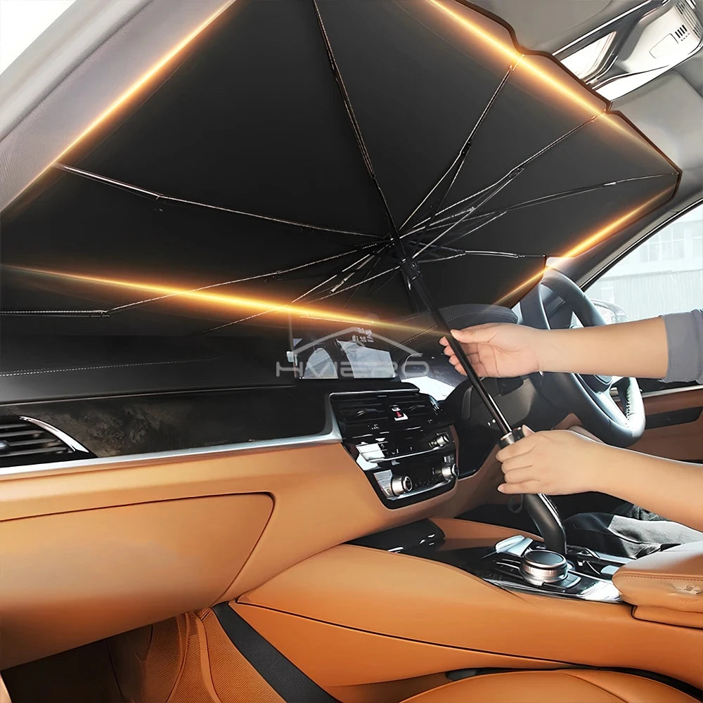 A hand opens a portable car sun shade umbrella inside a car, illuminating the interior with warm light.