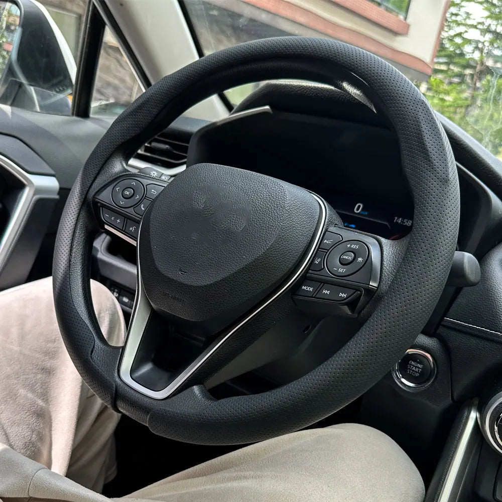 Innenansicht eines Autos mit schwarzem Lenkrad und Leder-Sitz.