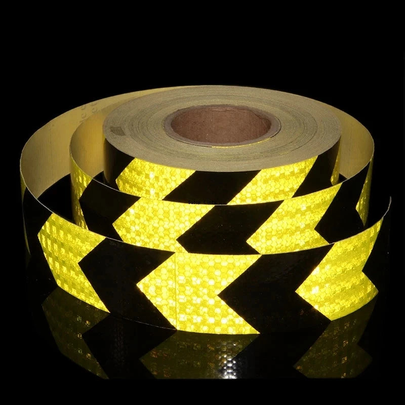 Roll of high-visibility fluorescent yellow and black reflective safety tape viewed from the side.