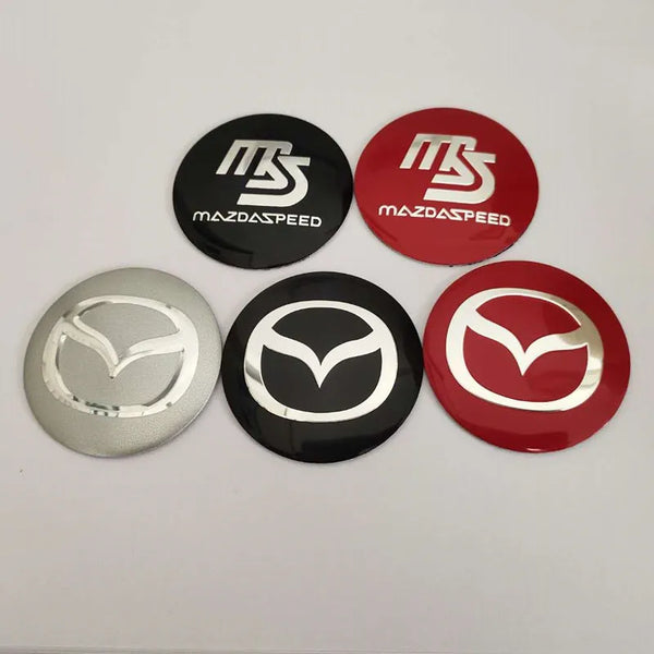 A collection of five round decals featuring the MazdaSpeed logo in black, red, and silver finishes.