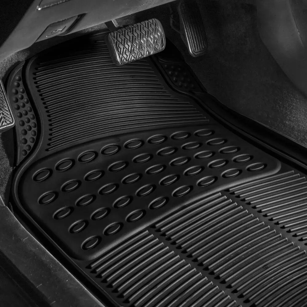 Close-up view of a black heavy-duty rubber floor mat with textured grips and drainage patterns.