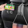 A hand is using a smartphone to attach a durable suede car seat back storage hook to a black car seat.