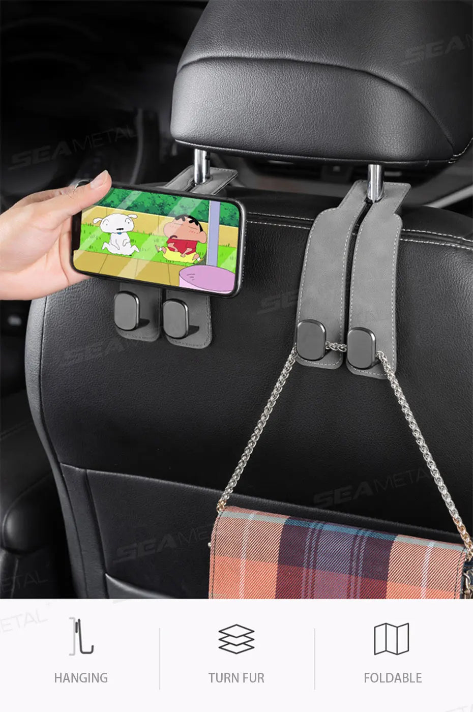 A hand is using a smartphone to attach a durable suede car seat back storage hook to a black car seat.