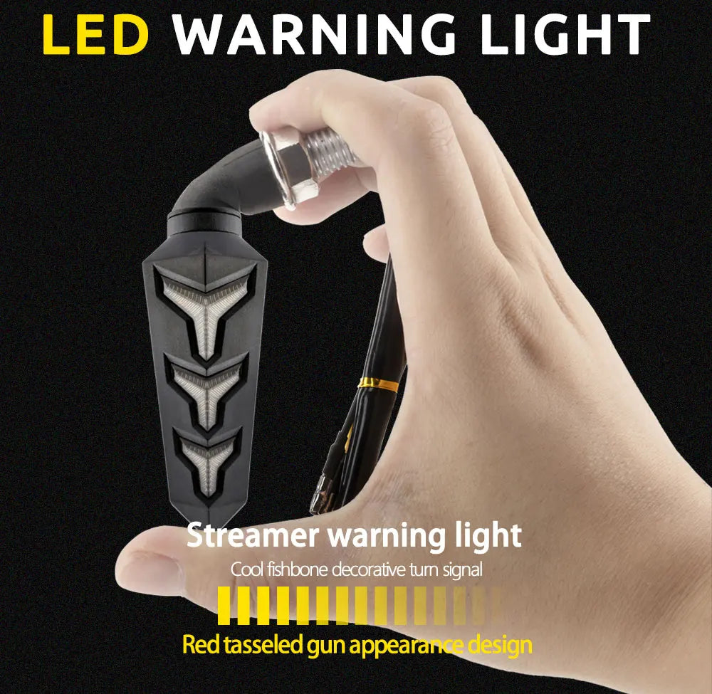 A hand holds a black LED warning light featuring a red tasseled gun appearance design.