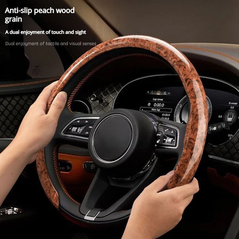 A hand grips an anti-slip steering wheel cover with peach wood grain inside a car
