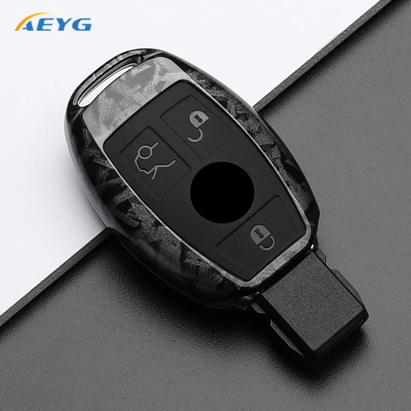 A black carbon fiber car key cover with various electronic buttons and a key slot.