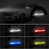 Close-up view of reflective door bumper strips installed on a car mirror, showing various light colors.