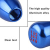 Close-up view of a blue aluminum gear shift knob with clear text markings.