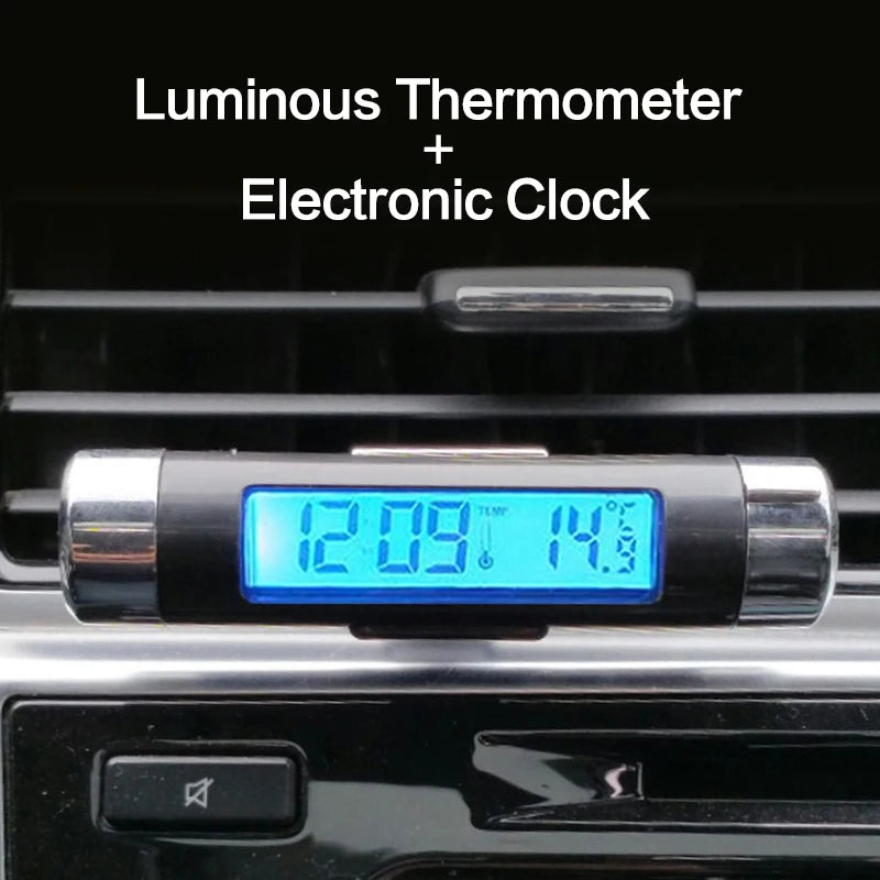 A digital thermometer and clock device with a blue backlight is mounted on a black car grille.