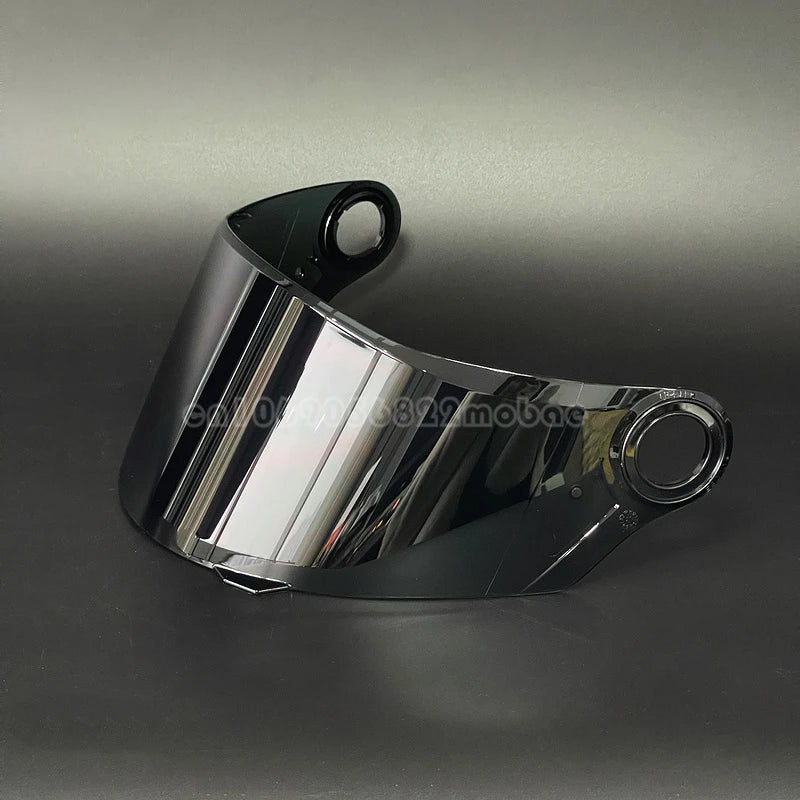 Visor de casco de motocicleta negro brillante visto desde un ángulo ligero contra un fondo gris oscuro.