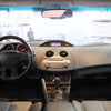Interior view of a car dashboard showing the steering wheel, instrument panel, and front seats.