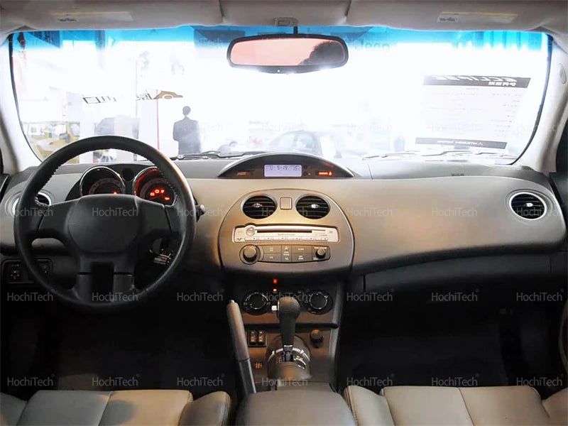Interior view of a car dashboard showing the steering wheel, instrument panel, and front seats.