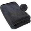 A black microfiber car drying towel with a circular sponge attached, shown from above.