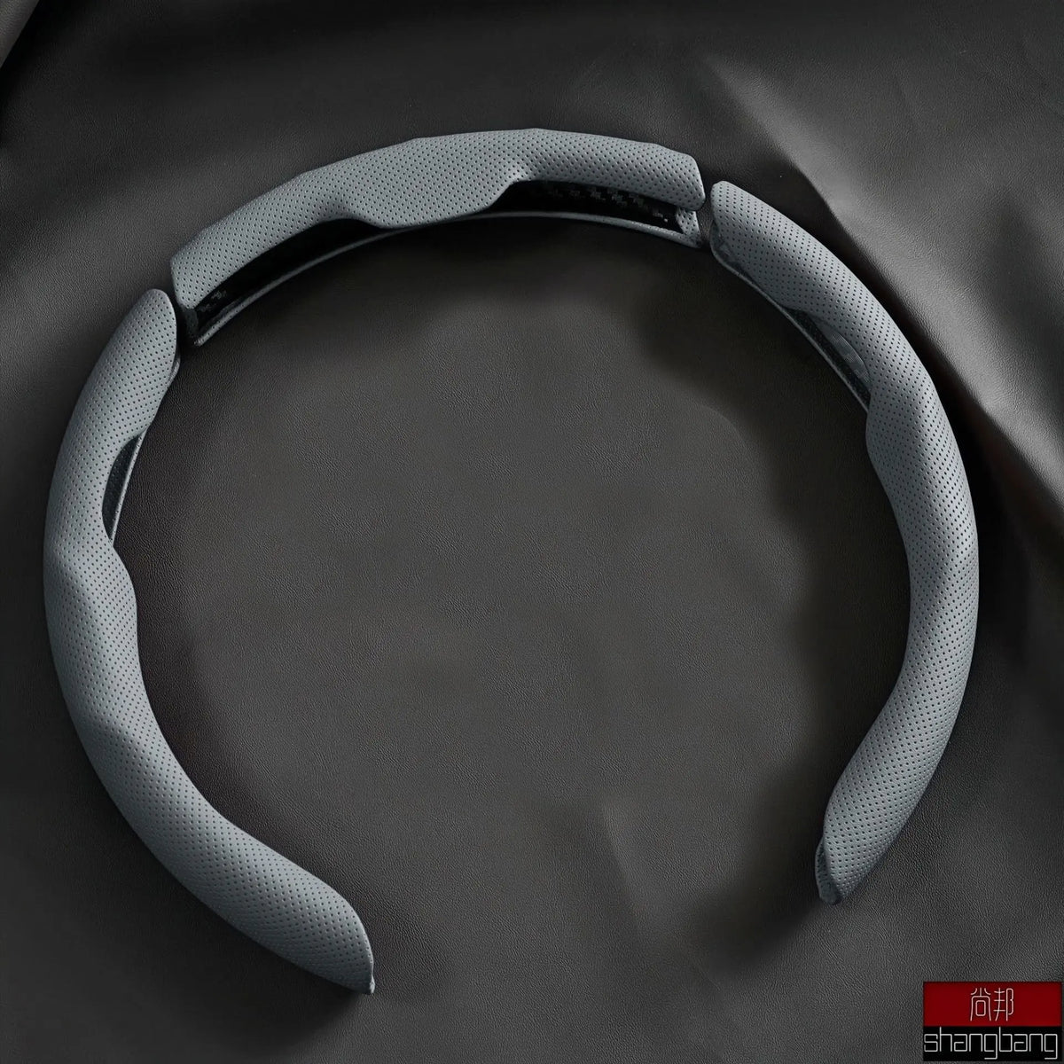 A gray breathable perforated leather steering wheel cover is shown against a dark background.