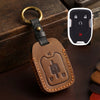 A brown leather key cover with a brass ring attached, featuring an electronic key fob and lock icons.