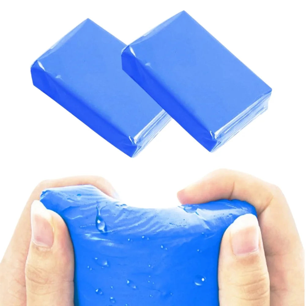 Two blue clay bars for car detailing are held in a hand, showing the product texture.