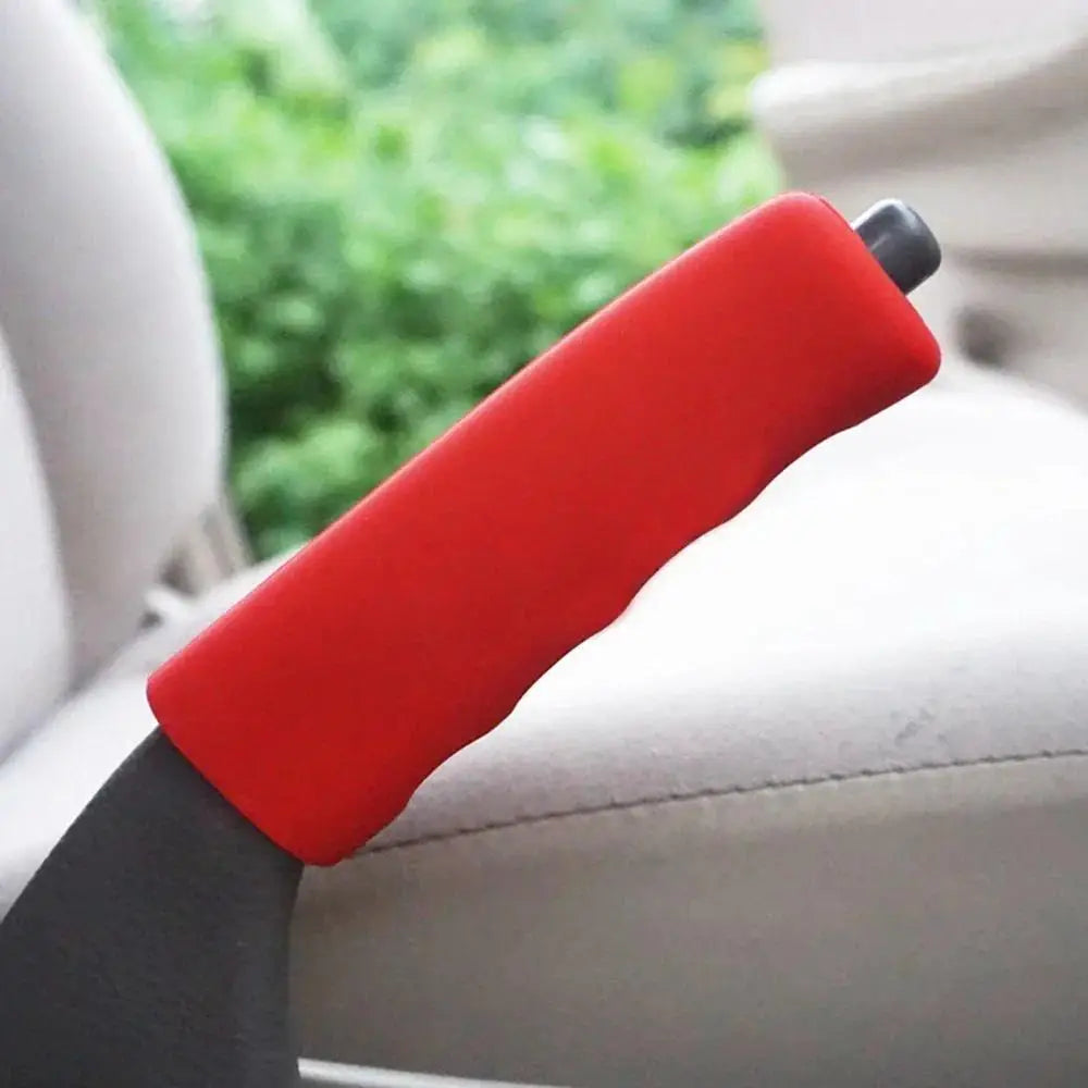 A red car gear shift knob and handbrake cover set is shown resting on a light-colored surface.