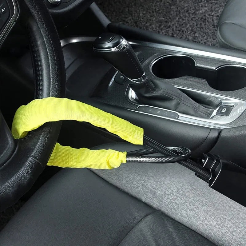 A yellow strap is shown attached to a steering wheel and seatbelt mechanism inside a car interior.