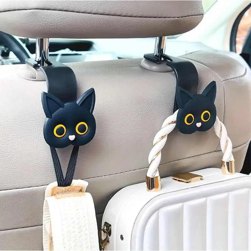 Black 3D cartoon cat headrest hooks used for securing storage items in a car