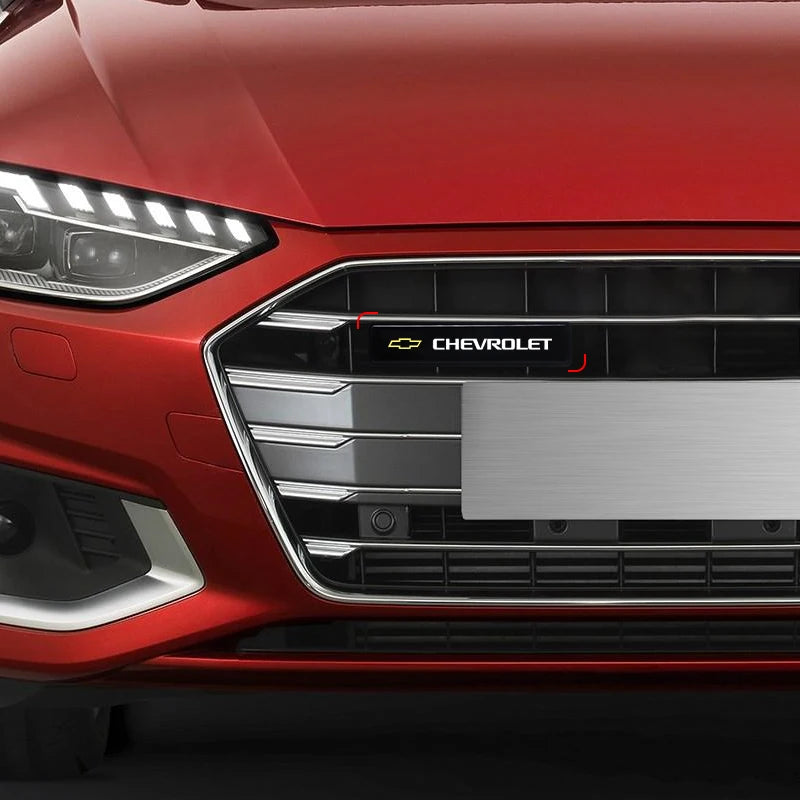 Close-up of a red car's front grille featuring an LED light and Chevrolet emblem.