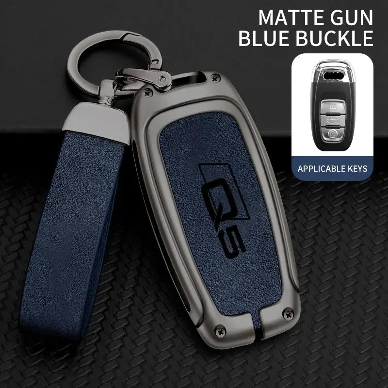 A matte gun blue buckle key fob cover made of zinc alloy with a silver loop and strap.
