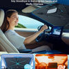A woman drives a car with a foldable sun shade installed on the windshield.