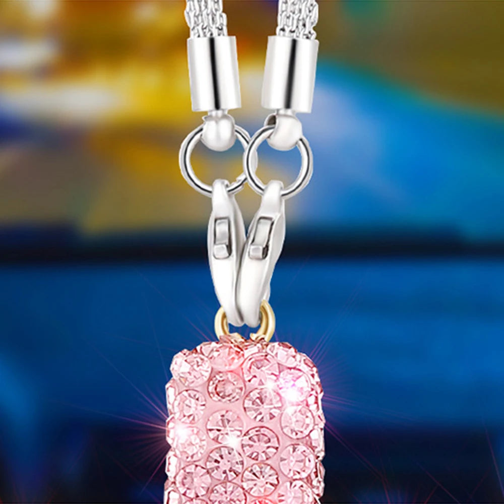 A pink, sparkling crystal ornament pendant suspended from a silver stainless steel chain.